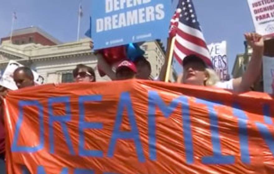 People marching in support of DACA hold a banner. Still from Washington Post/Reuters video