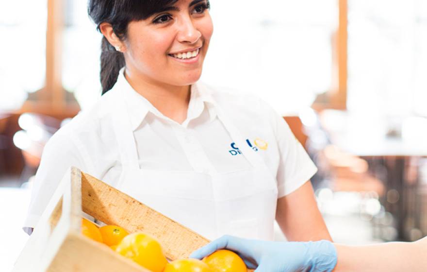 female student with crate of oranges