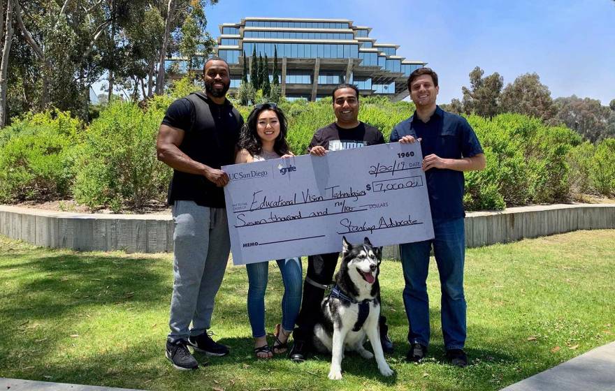 Educational Vision Technologies team members Lyn Scott, Shelly Bae and co-founders Monal Parmar and Jason Bunk hold first-place prize check after winning a pitch competition in June 2019.