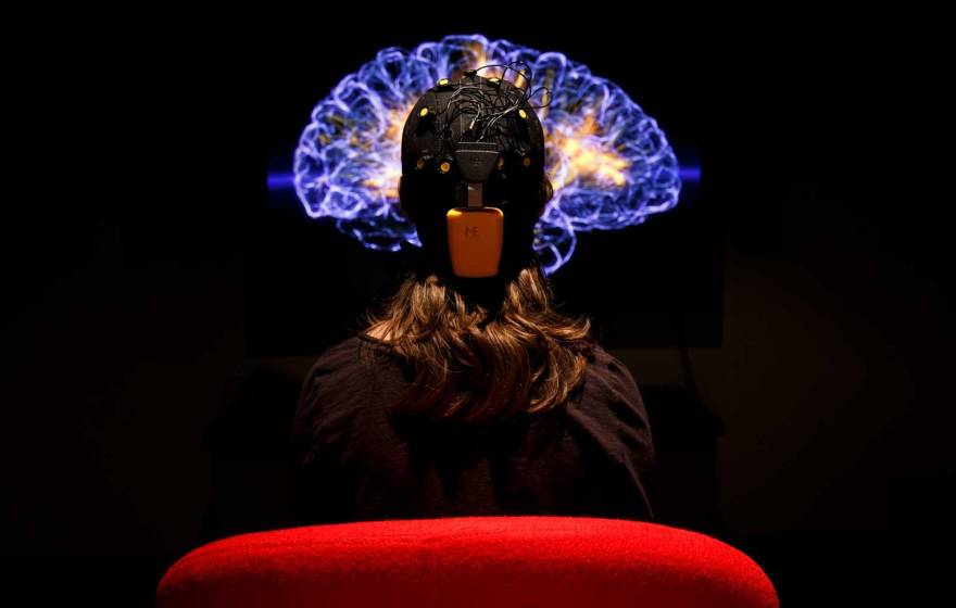 A person hooked up for an EKG looking at an image of the brain