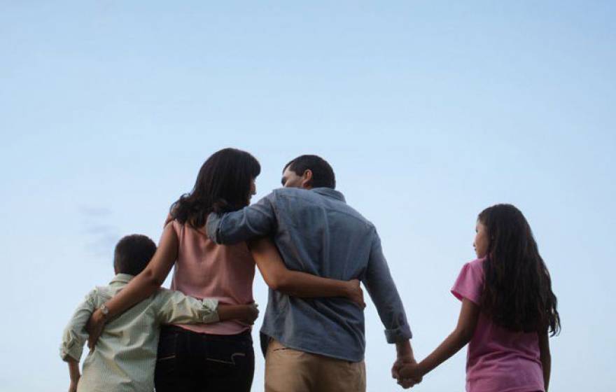 Family walking forward with sky background