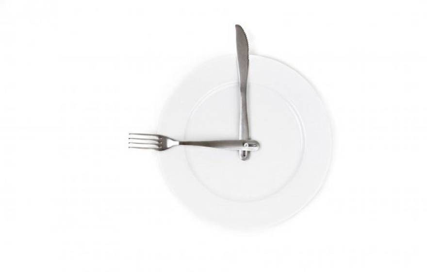 Plate with a fork and knife positioned like hands of a clock