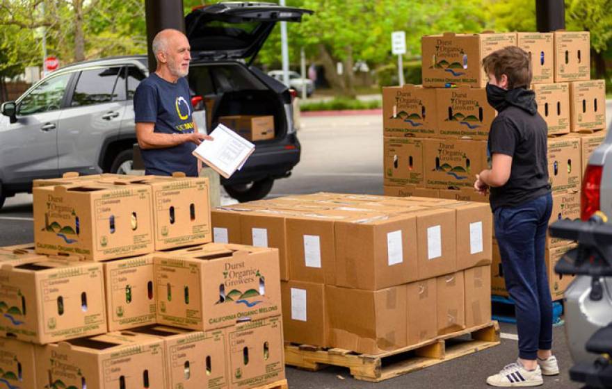 Robb Davis and teen boy organizing food boxes outside