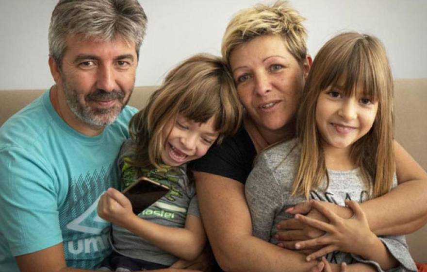 Family sits on the couch together