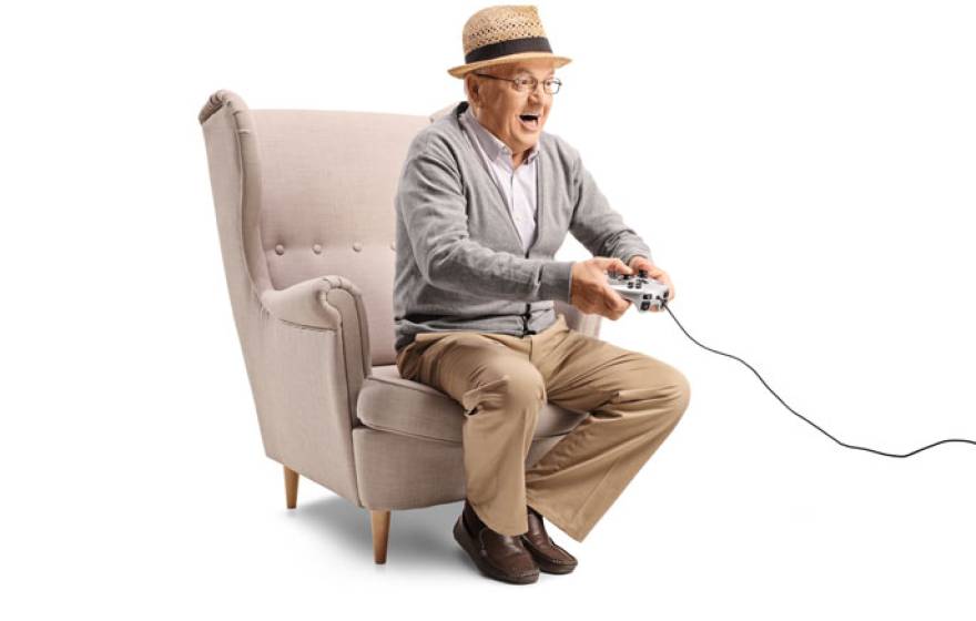 Senior man in a hat playing video games excitedly