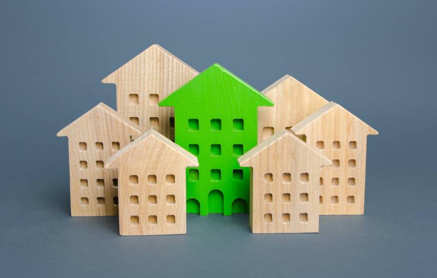 Simple wooden blocks look like buildings with a green-colored one in the middle