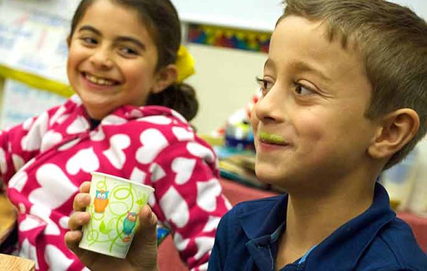 child drinking green smoothie