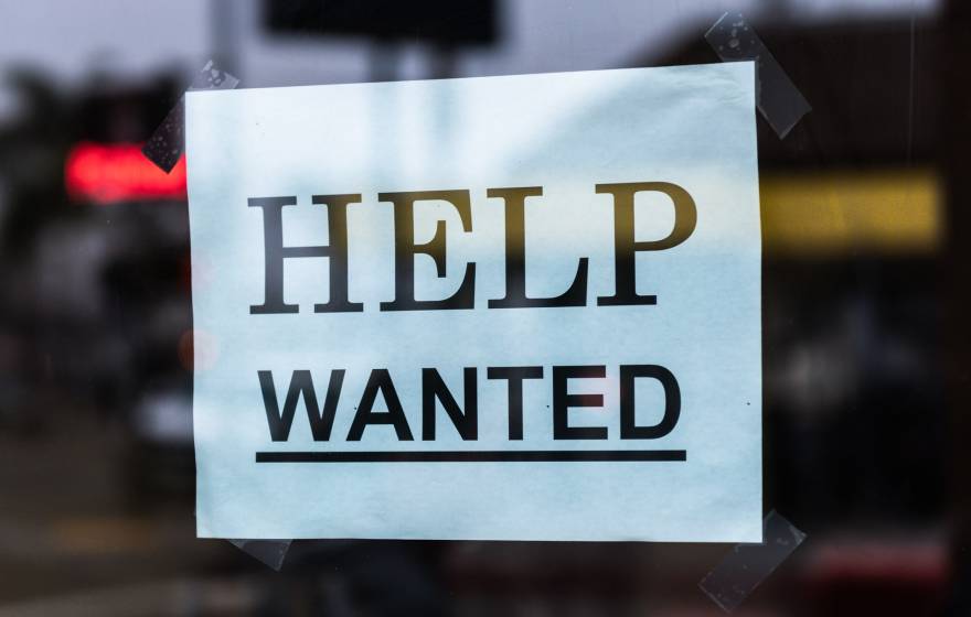 Help Wanted sign in a shop window