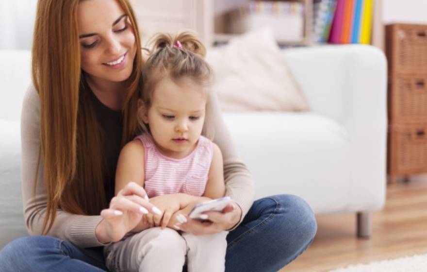 Mom and toddler looking at a cell phone