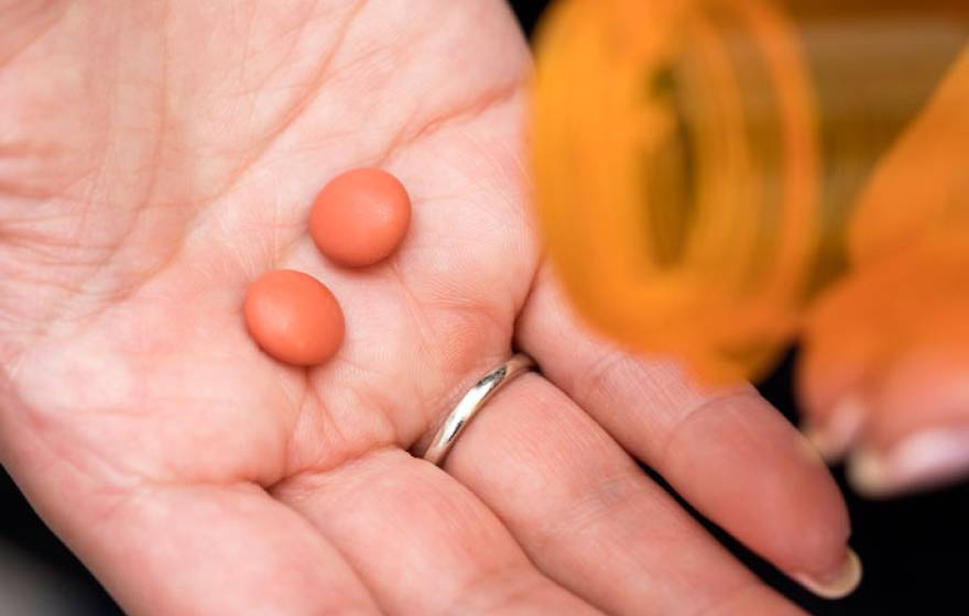 Ibuprofen pills in someone's hand