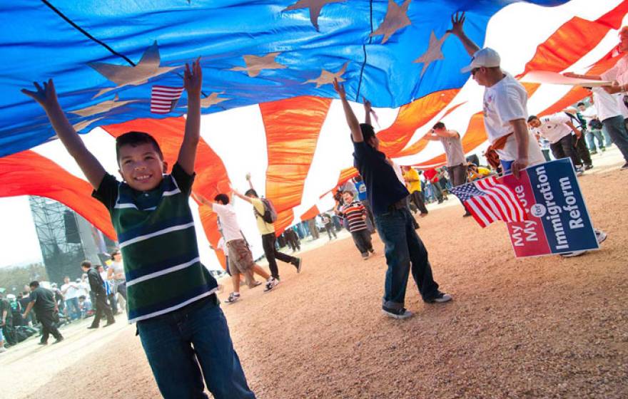 A child and several others under a large American flag