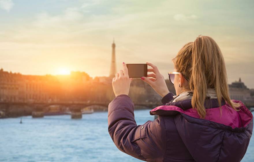 woman photographs Paris with smartphone