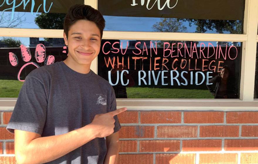 Jerry points at a window with names of colleges on it