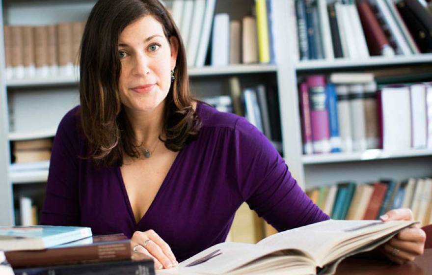 Kara Cooney at a desk with an open book