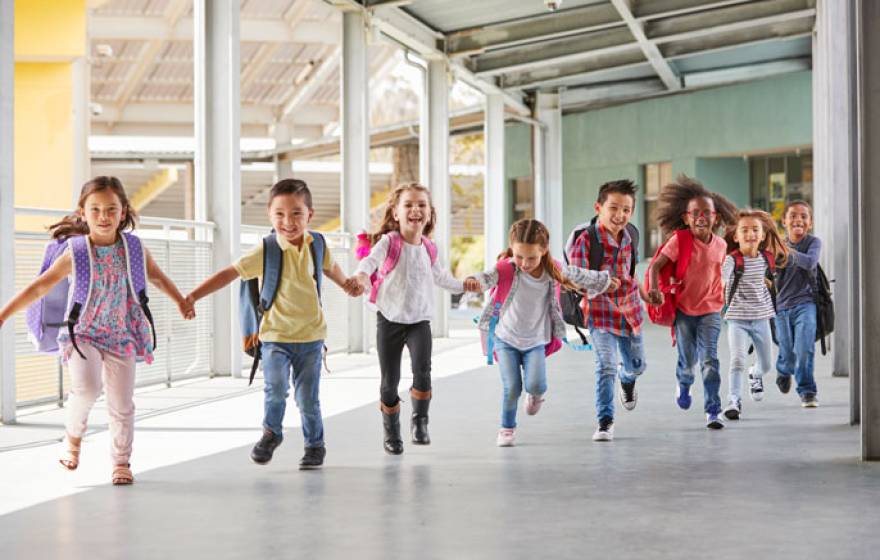 Kids run through an outdoor hallway