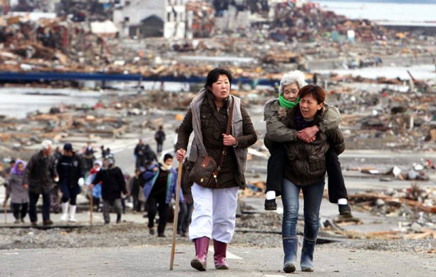 Two women walking, one carrying another, older woman