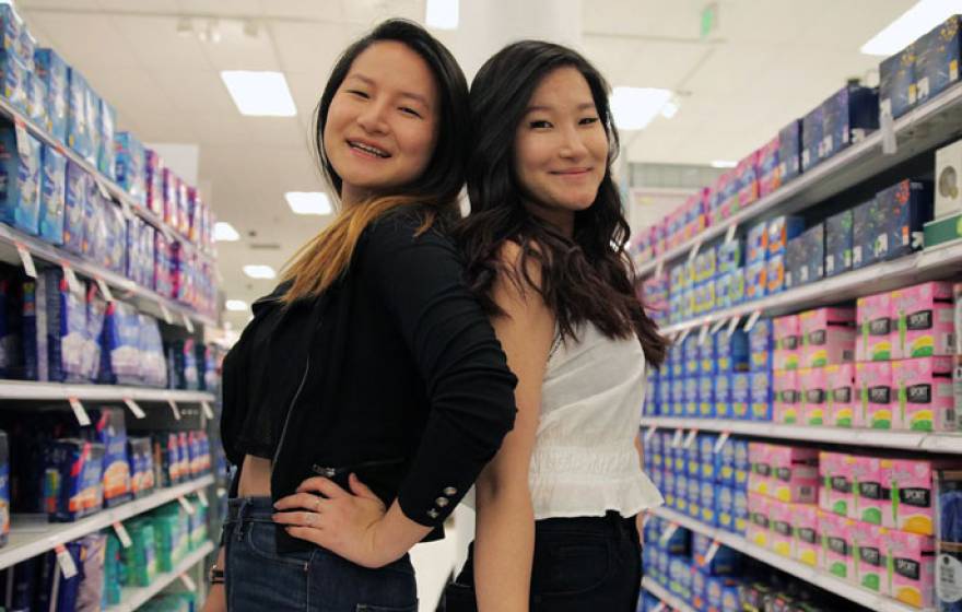 Lee sisters pose together in the feminine products aisle of a store