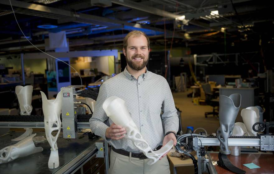 Joshua Pelz holding a 3D-printed prosthetic