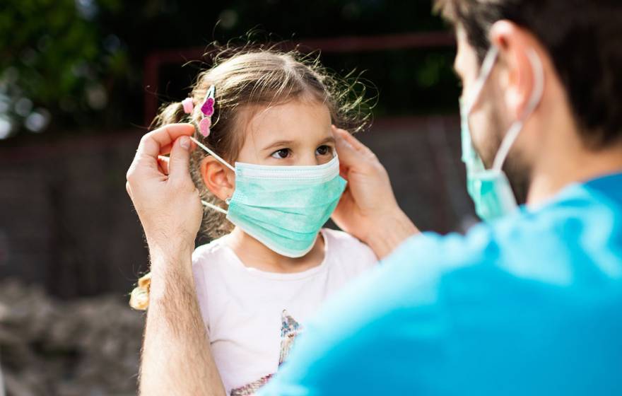 Man puts mask on child