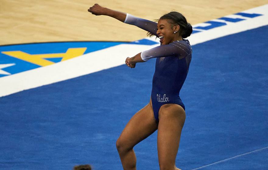 Nia Dennis smiling and pumping her fist while on the floor