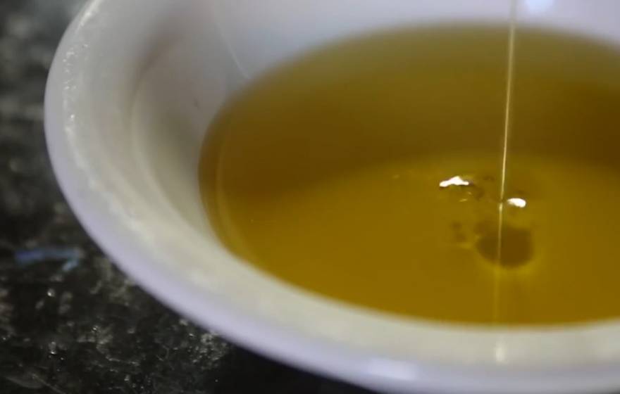 Olive oil being poured into a dish, the first frame of the video banner