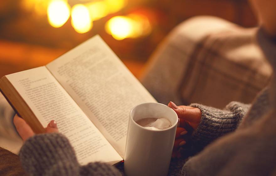 Woman reading book with cocoa