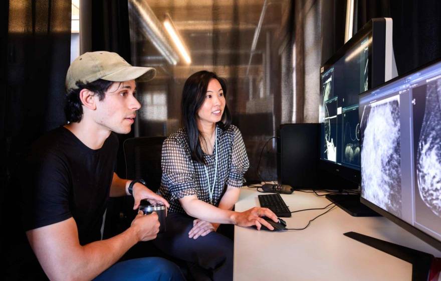 Researchers Maggie Chung and Adam Yala look at a mammogram scan on a computer screen