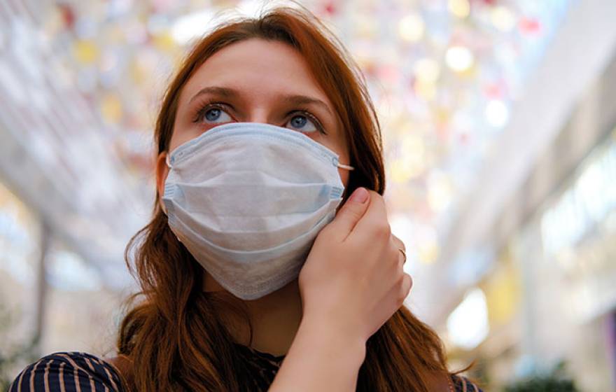 Woman thinking about taking off mask