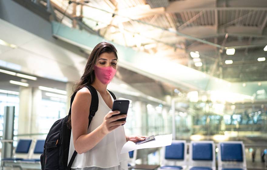 Woman at airport, checking her cell phone