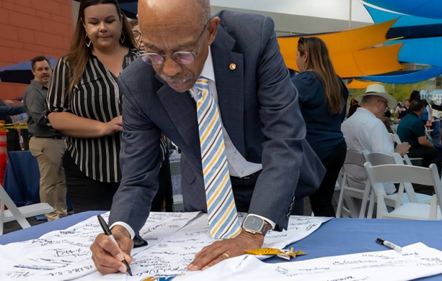 UC President Michael V. Drake M.D. signs a white coat