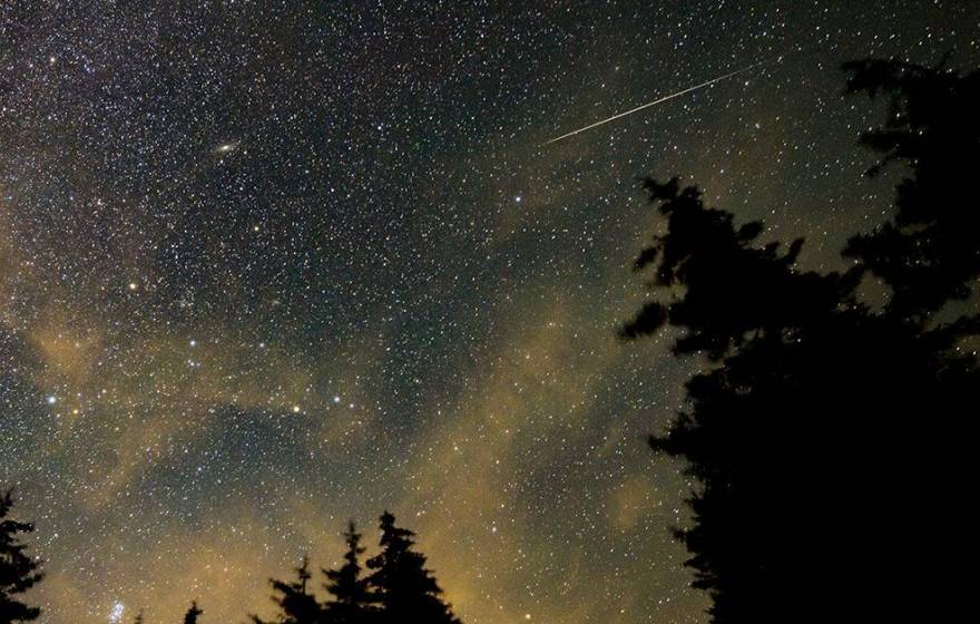 A view of a night sky with a meteor streaking across