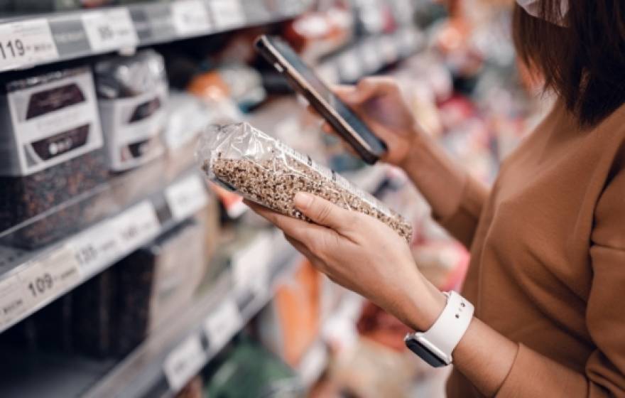 A woman looking at a nutrition label in a store