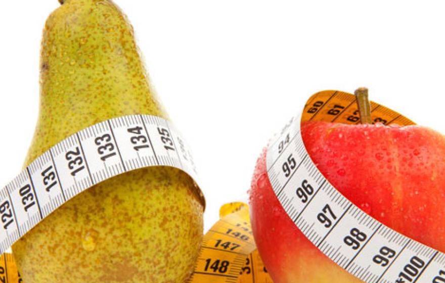 Pears and apples with measuring tape wrapped around them