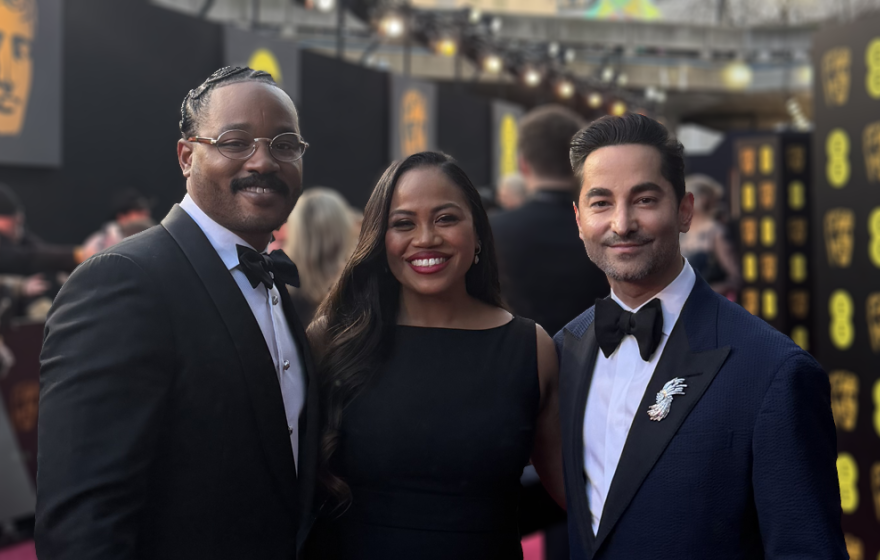 3 people in formal wear on the red carpet