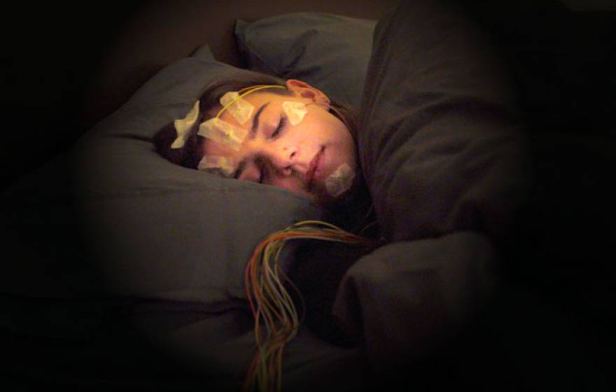 Woman sleeping with sensors on her head