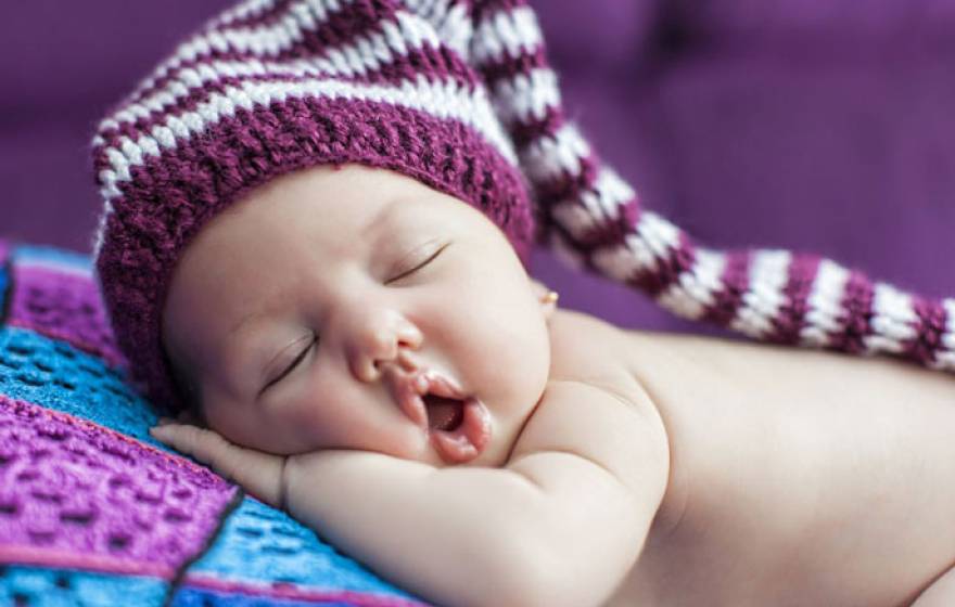 Baby sleeping in purple hat