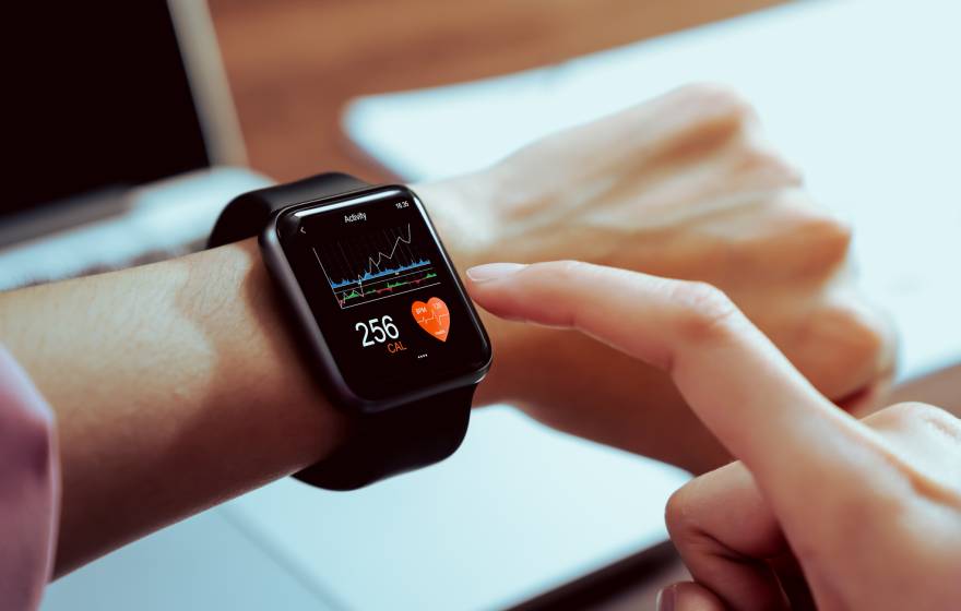 A person taps their smartwatch with the pointer finger of their other hand