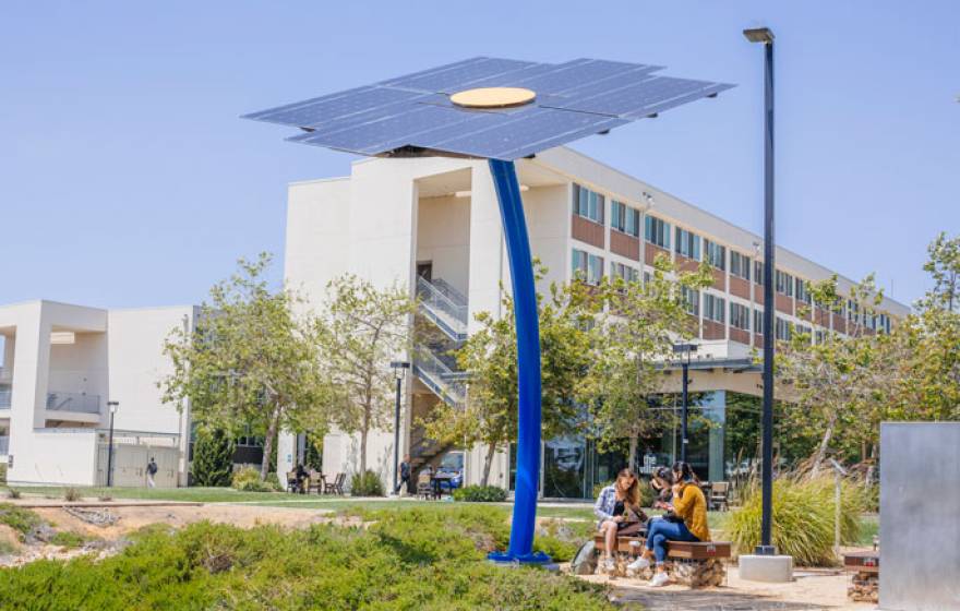 Outdoor solar panel charging station with students beneath