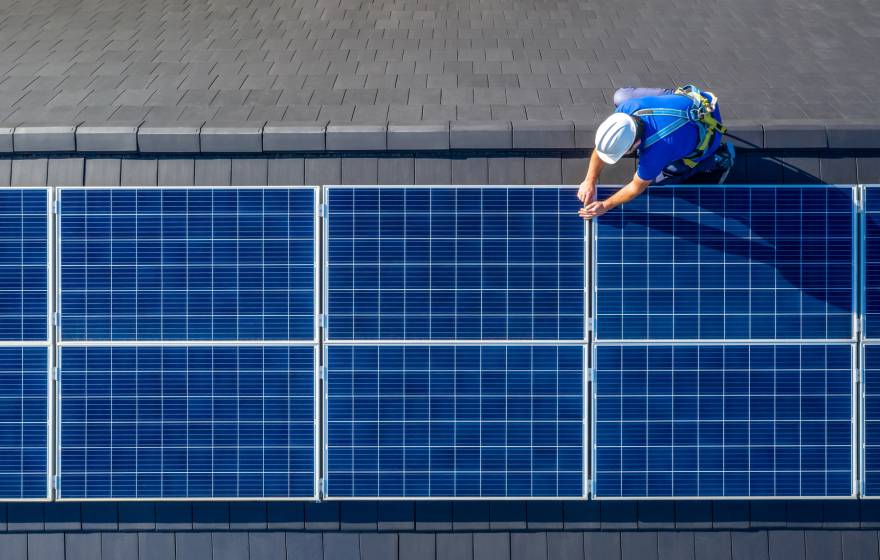 Man photographed from above working on a solar panel