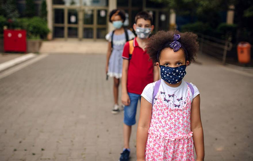 A line of young masked elementary school students