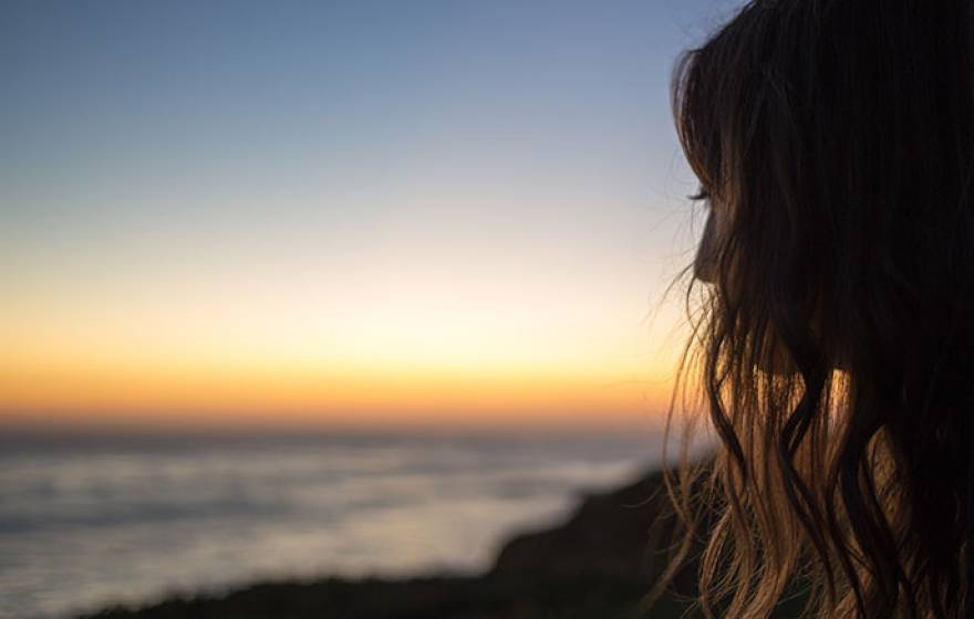 Teen staring at the beach away from the camera