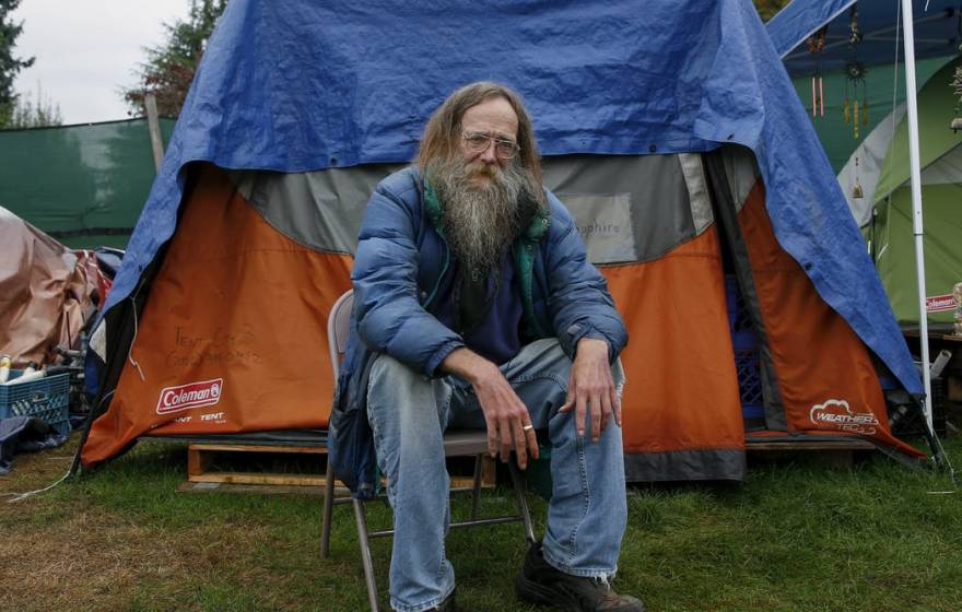 Lantz Rowland poses in front of his tent outside Seattle, Washington.