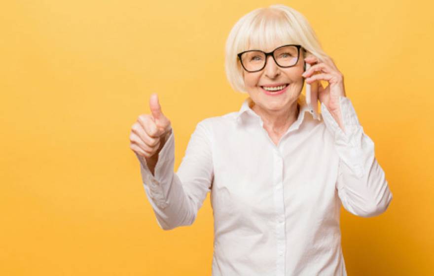 Thumbs up from an older woman who is standing