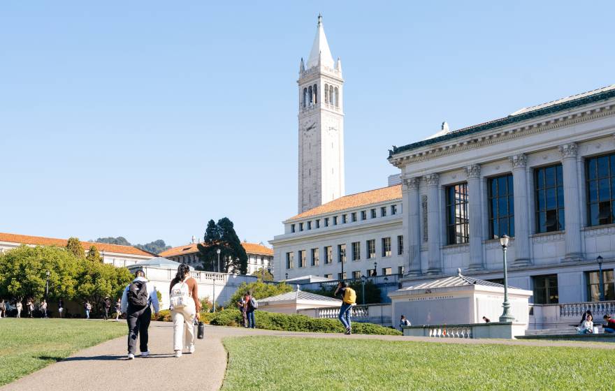 A view of students walking on the UC Berkeley campus on a clear day, Sather Tower ahead