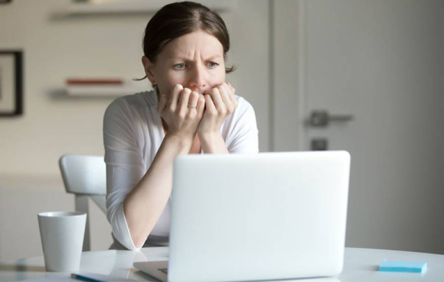 Woman anxiously looking at computer