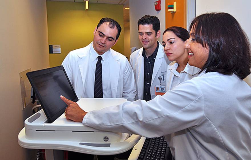 UCLA Dr. Michelle Bholat (right) gives a lesson on electronic medical records to international medical graduates (from left) Hendry Perez Pascual, Marcus Medina and Gloria Monsalve