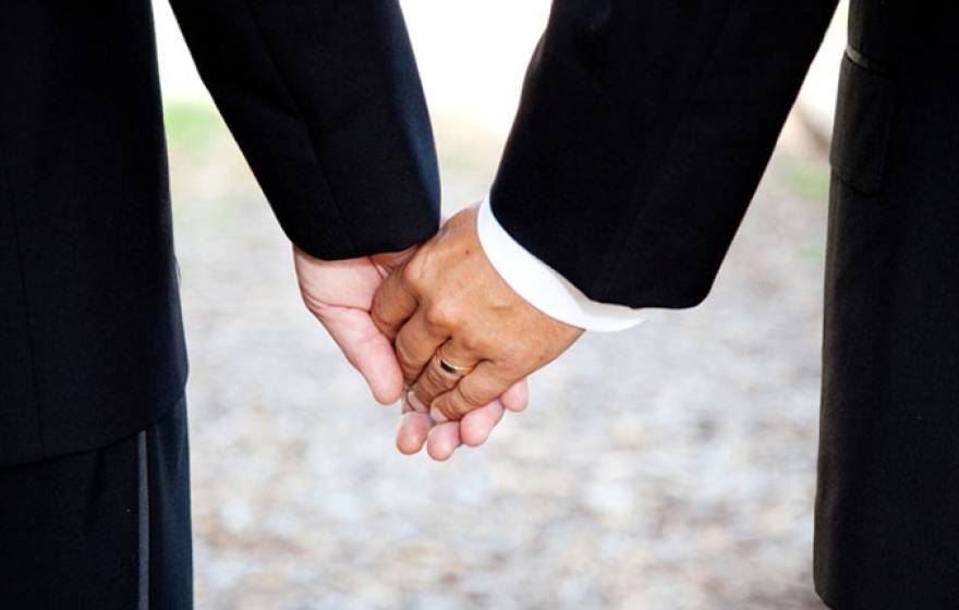 newlywed men hold hands