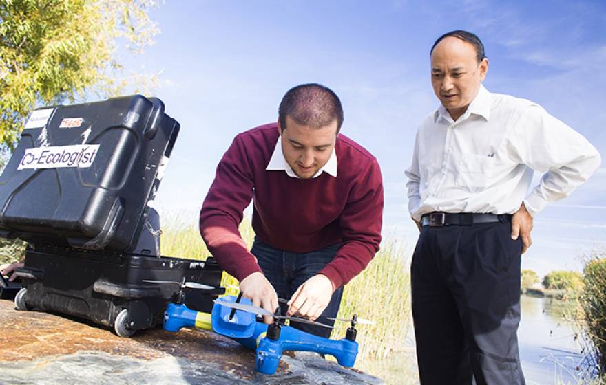 UC Merced professor YangQuan Chen (right) and student Brendan Smith work with drones.