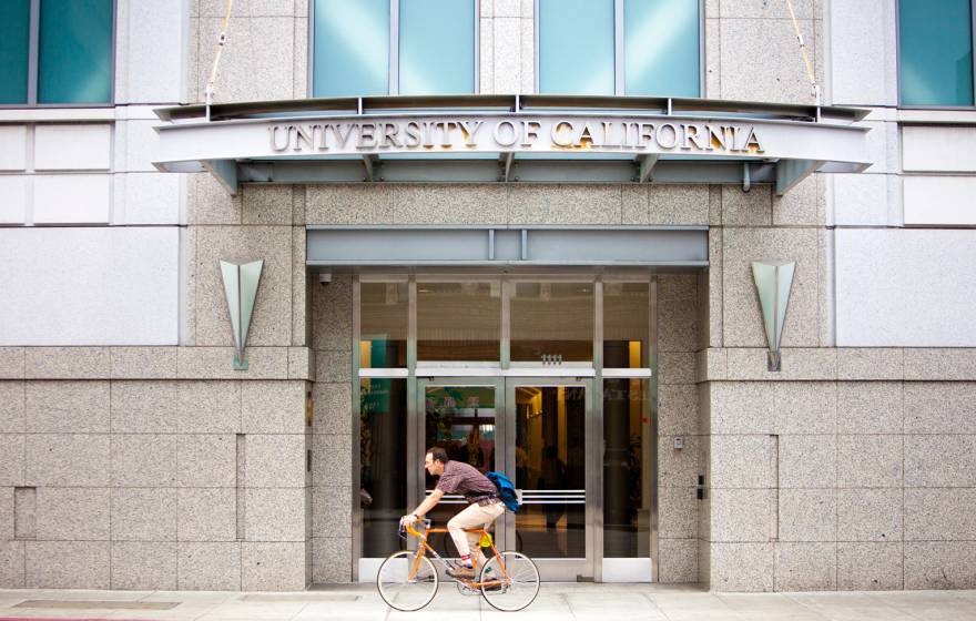 A cyclist goes by the UCOP building in Oakland, Calif.