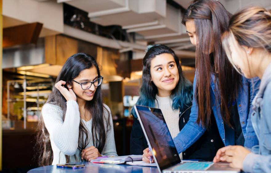 Four female students study together at a table